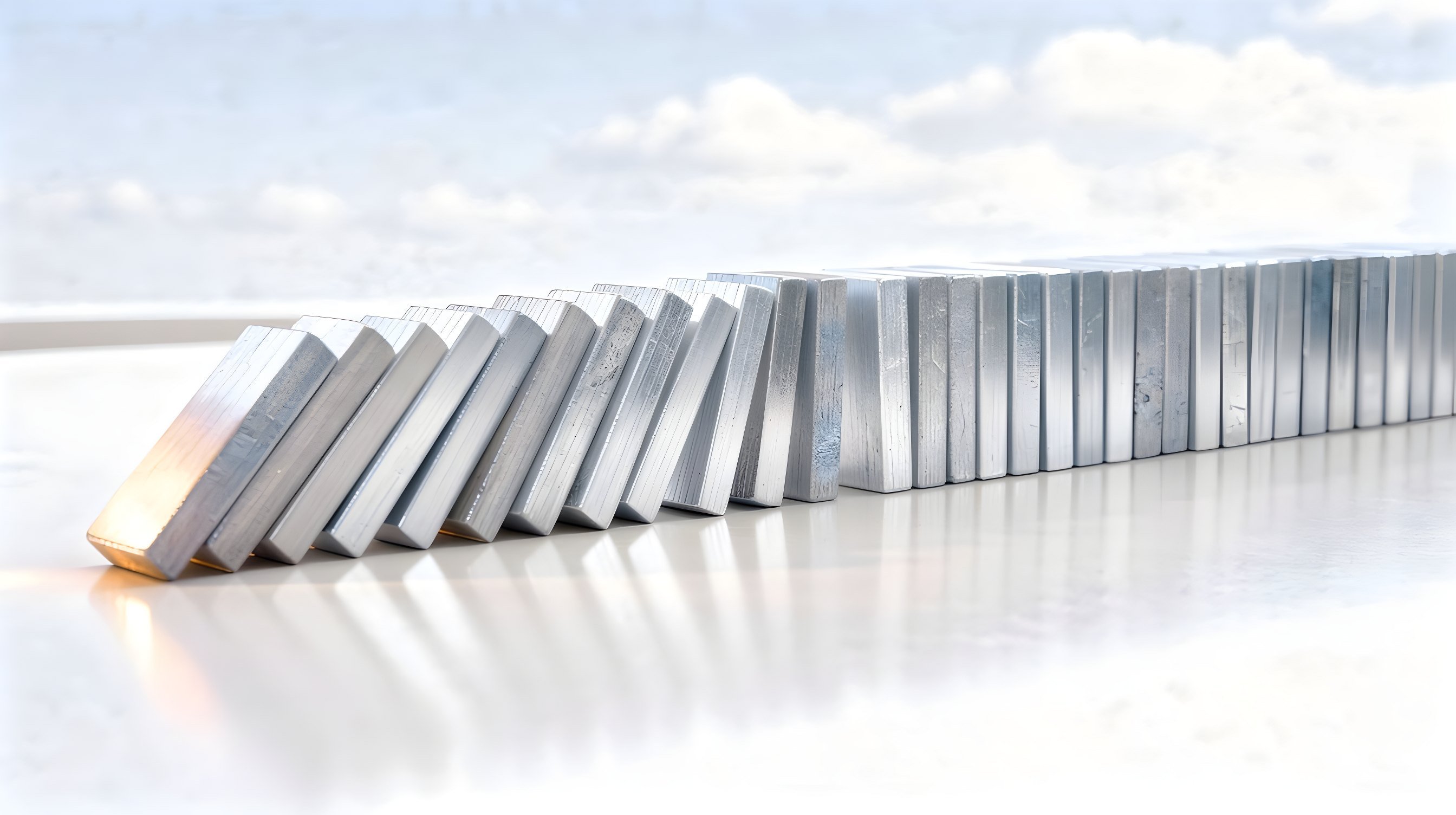 Illustration: a long row of plain dark wooden tiles on edge, the first half toppled in sequence, a warm light at the toppled end.